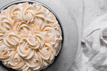 Overhead view of Buttercream rosette cake on a cake stand, top view of Cake covered in buttercream rosettes, process of decorating a cake with roses