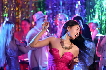 Young Asian woman dancing at party in night club