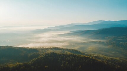 Fototapeta premium Misty mountain landscape with layers of fog and rolling hills in morning light serene nature scene
