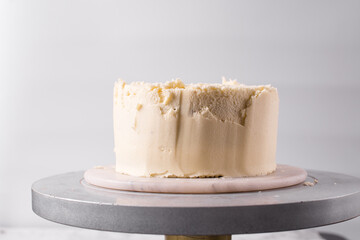 Cake being covered in buttercream frosting, Rustic cake being covered in american buttercream, process of decorating a cake