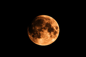 Obraz premium Detailed view of a radiant orange moon illuminating the night sky expanse