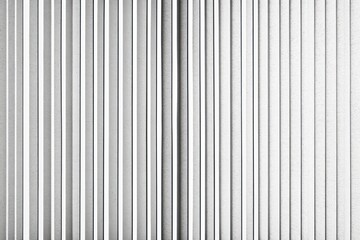 Obraz premium Close-up view of a vertical white wall with evenly spaced textured panels creating a repetitive linear pattern