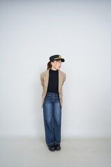 A collection of studio portraits featuring a stylish young woman posing in various confident stances against a clean white background.