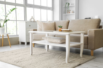 Interior of living room with soft couch, table and window
