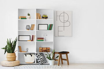 Interior of light room with bookshelf, poster and plants