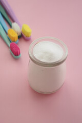 baking soda and tooth brush on pink background 