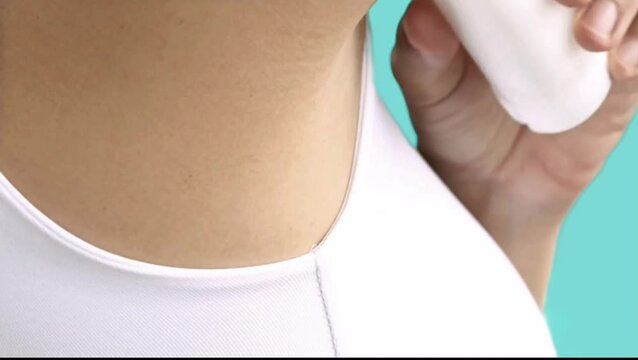 a woman who applies deodorant to her armpits