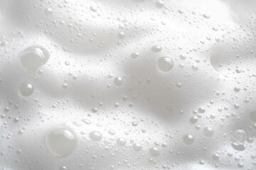 Close-up of white soap foam bubbles creating a soft, airy texture with reflections on a white surface