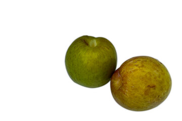  Two ripe pluots, one green and one yellow, on a white background.