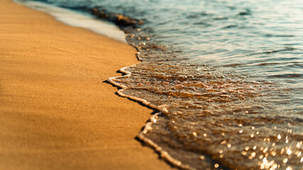 Sand on the beach and sea waves in the morning, orange tone.