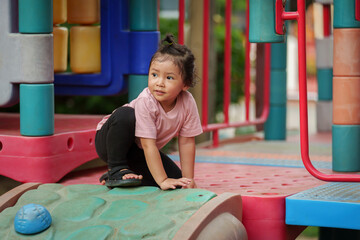 happy toddler girl playing at a outdoor playground in park
