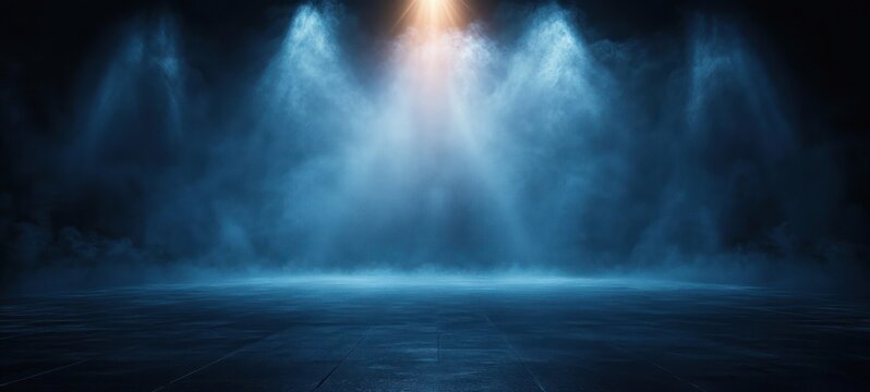 Dimly lit empty stage with blue spotlights and mist creating a mysterious and atmospheric scene