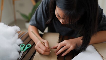 Asian girls doing creative DIY activity at home, developing skills and imagination in a...