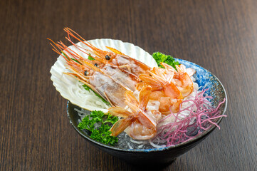 A plate ofMu Dan shrimp on ice with wasabi and soy sauce.