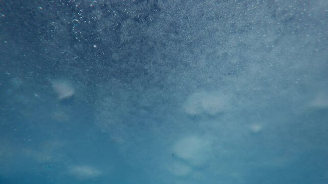 Moving forward under thin spring ice, Texture of blue ice with air bubbles frozen in it, Underwater view, Close-up, Natural background 