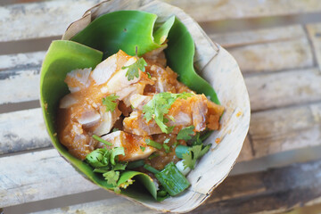 A vibrant dish served in a banana leaf, showcasing fresh ingredients and rich flavors.