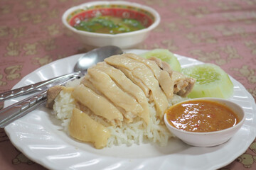 Delicious plate of chicken rice served with cucumbers and chili sauce, perfect for food lovers and culinary enthusiasts.