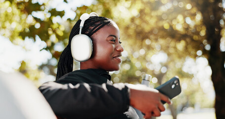 Black woman, relax and headphones for fitness in city by listening to music, streaming audio and...