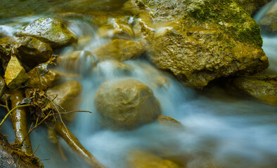 small mountain brook rushing over a stones in mountain canyon