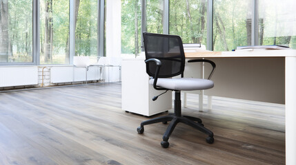 Fototapeta premium Minimalist office space with a sleek chair, bathed in daylight. Elegance and simplicity in modern workspace design.