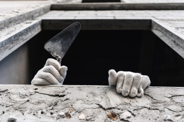 Construction worker troweling concrete urban building site action shot close-up view industry focus