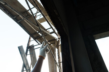 Obraz premium Construction worker inspecting framework urban site action shot daylight close up safety and precision in building