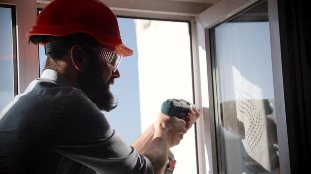Construction worker using drill on window installation project	