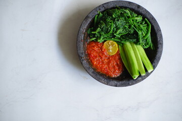 fresh vegetables and sambal in a stone plate 
