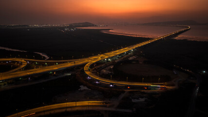 India's longest sea bridge: Trans-Harbour Sea Link. Atal Setu sea bridge in Mumbai, Maharashtra, India. Time-lapse of a city at night with bright skyscrapers and a dense network of glowing buildings.