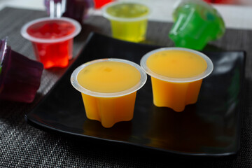 A view of some mango flavored fruit jelly cups, on a plate.