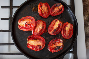 A top down view of a comal of roasted tomato slices.