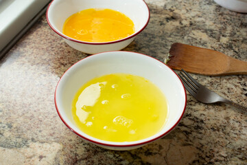 A view of the separation of egg yolk and egg whites in bowls.