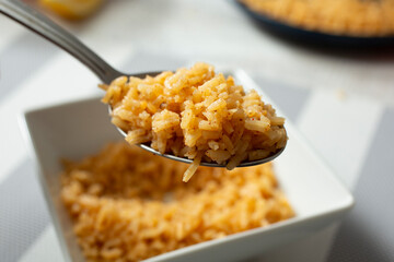 A closeup view of a spoonful of Mexican rice.
