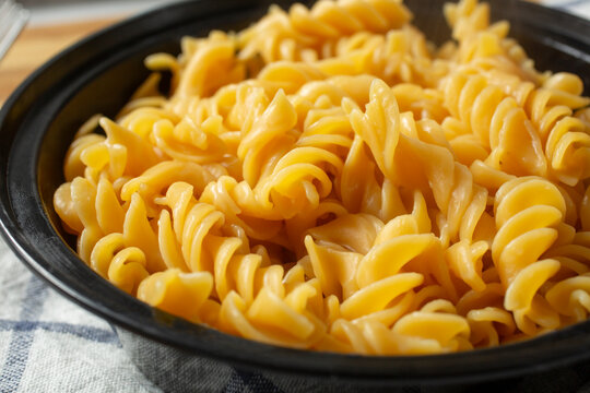 A closeup view of cooked gluten-free rotini pasta in a bowl.