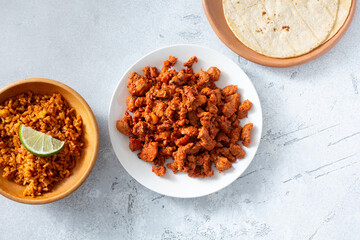A top down view of a pile of al pastor meat, on a plate.