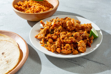 A view of a pile of pollo asado meat on a plate.