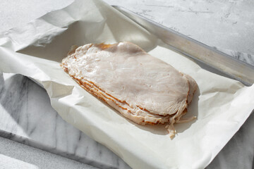 A view of a stack of turkey breast slices, on a tray.