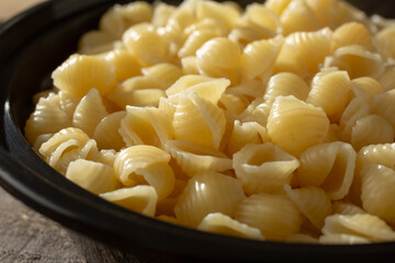 A closeup view of a bowl of cooked small shell pasta.