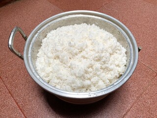 Close up of white rice on the pan in kitchen. Rice after being cooked using a pan. Staple food of...