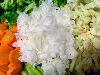 Close up some vegetables like snow mushroom, carrot, broccoli, cauliflower, and capri