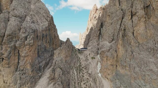 Toni Demetz Hut perched in rocky Dolomites pass surrounded by dramatic peaks