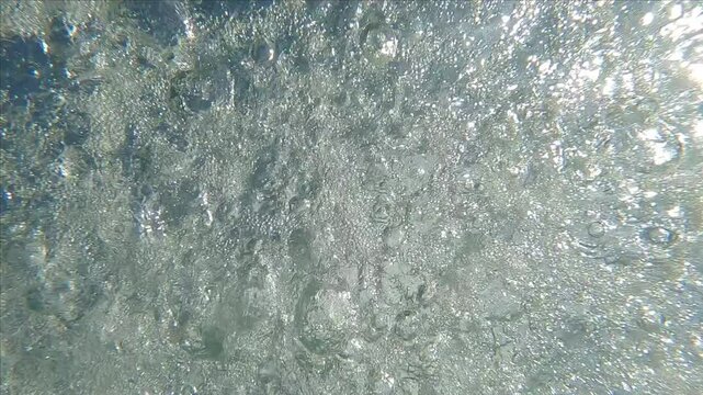 Underwater view of large raindrops on the surface of water on clear sunny day with blue sky, Backlight (Contre-jour), Underwater shot, Slow motion