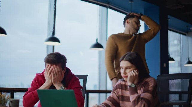 Shocked business people looking laptop reacting on failure in office.
