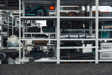Equipment storage area organized with various tools and containers in a modern workspace during daylight