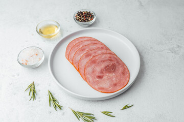Sliced sausage on white plate with herbs and spices