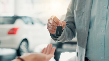 Dealership, salesman and customer with hands for car keys, test drive and success purchase of motor. Showroom, people and giving equipment in closeup for buying vehicle, rental service and automobile