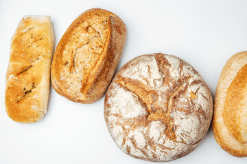 Variety of freshly baked bread loaves arranged on a white surface