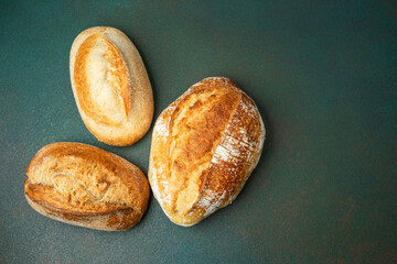 Freshly baked artisanal bread loaves on a green surface
