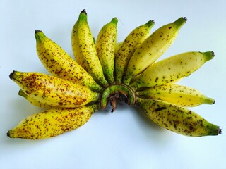 A bunch of ripe bananas on a white surface