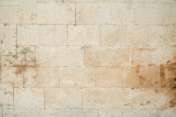 Antique ancient stone wall masonry texture background. Old wall made of beige stone blocks 